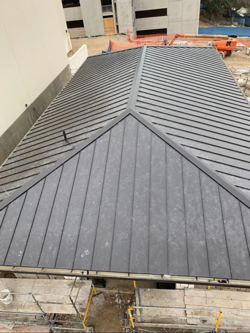 Commercial metal roof construction with crane equipment in Battlement Mesa